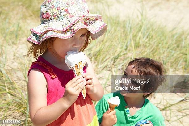 children eating ice cream on beach - girl eating messy ice cream cone stock pictures, royalty-free photos & images