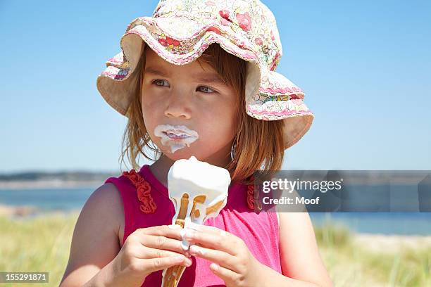 girl eating ice cream on beach - girl eating messy ice cream cone stock pictures, royalty-free photos & images