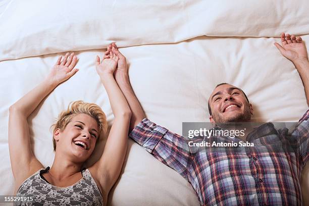 couple relaxing on hotel room bed - confort at hotel bedroom stock pictures, royalty-free photos & images