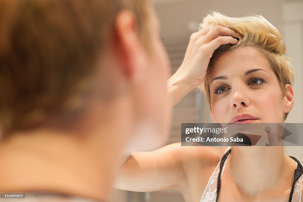 Woman examining herself in mirror
