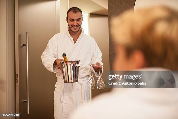 man bringing girlfriend champagne - accappatoio foto e immagini stock