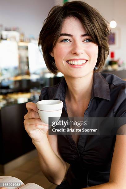 smiling woman having coffee in cafe - espresso trinken stock-fotos und bilder