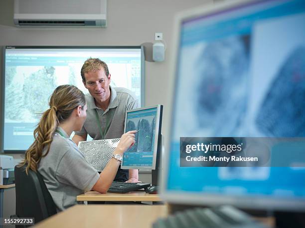 trainee forensic scientists examining fingerprints on screens in laboratory - forens fotografías e imágenes de stock