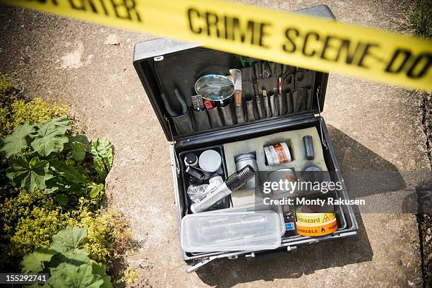 forensic toolkit at crime scene with police tape - strafrechtliche ermittlungen stock-fotos und bilder