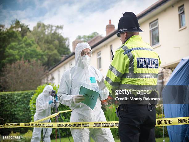 policeman talking to forensic scientists at crime scene - uk police stock-fotos und bilder