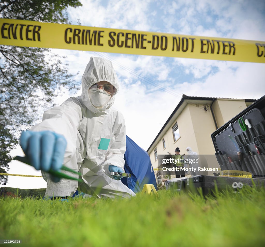 Close up of forensic scientist taking sample at crime scene, surface level view