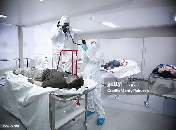 forensic scientist photographing artificial body in mortuary at training facility - morgue ストックフォトと画像