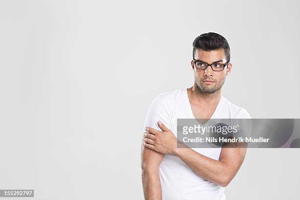 curious man holding arm - cabello negro fotografías e imágenes de stock