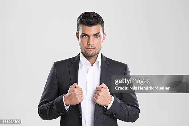 businessman adjusting his suit - solapa fotografías e imágenes de stock