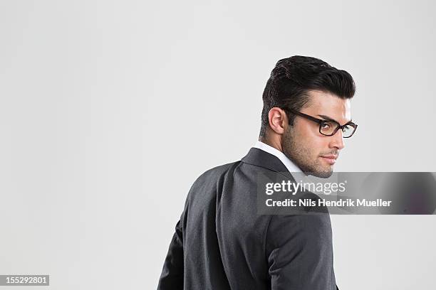 businessman looking over his shoulder - turning imagens e fotografias de stock