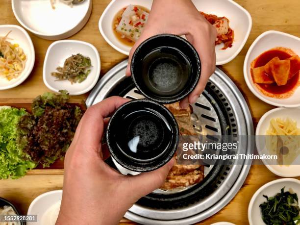 friends having a good time eating korean bbq. - korea traditional stock pictures, royalty-free photos & images