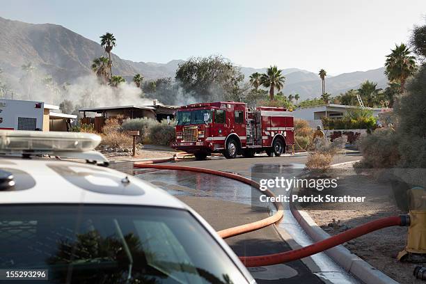 a police car and a fire truck at the scene of a burning house in a suburb - fire hydrant stockfoto's en -beelden