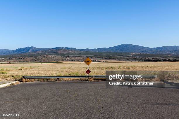 an end road sign and mountain ranges behind - señal de calle sin salida fotografías e imágenes de stock