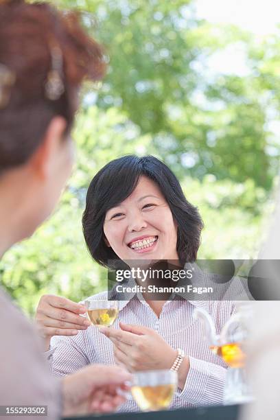 senior woman smiles with tea - mature women cafe stock pictures, royalty-free photos & images