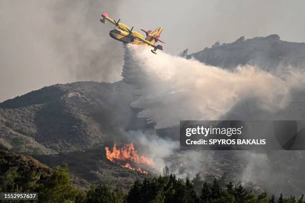 Fire fighting aircraft drops water over a wildfire close to village of Vati in the southern part of the Greek island of Rhodes, about 70 km southwest...