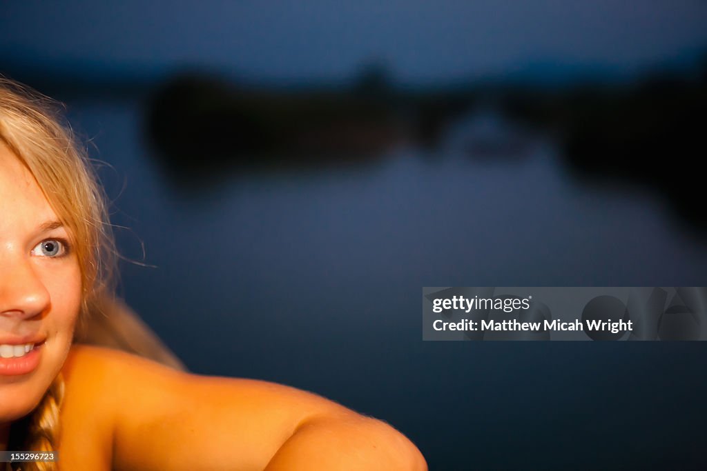 A girl watches a sunset.