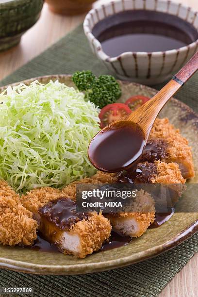 putting tonkatsu sauce on tonkatsu - tonkatsu stock pictures, royalty-free photos & images