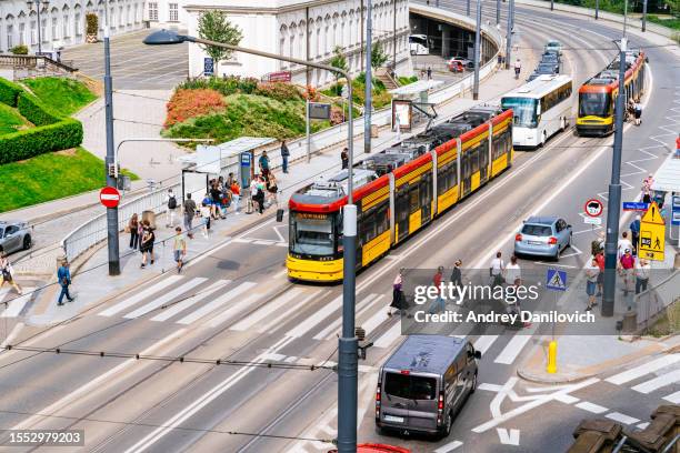 carretera bulliciosa en el centro de varsovia con tranvía acercándose a una parada. - varsovia fotografías e imágenes de stock
