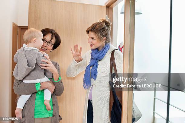 woman waving to her daughter - babysit stockfoto's en -beelden