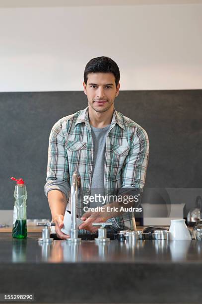 man washing dishes in the kitchen - adult man brussels stock pictures, royalty-free photos & images