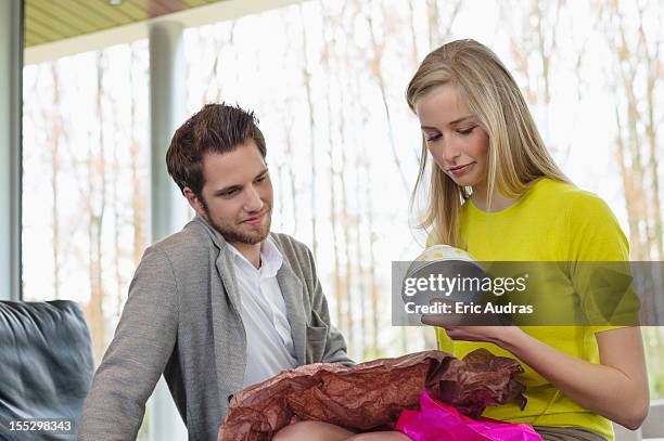 happy woman looking at a present given by her boyfriend - bad gift stock pictures, royalty-free photos & images