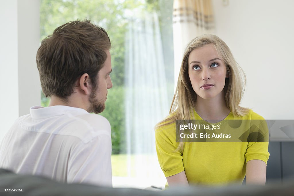 Couple sitting together, woman ignoring boyfriend