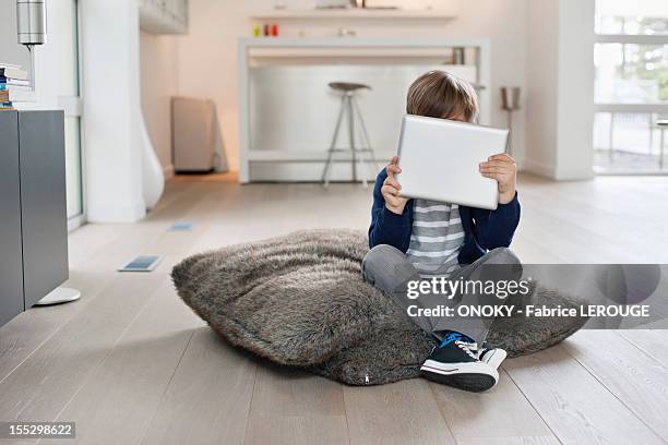 boy hiding his face with a digital tablet - hid face stock pictures, royalty-free photos & images