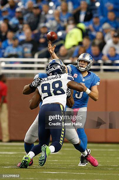 Matthew Stafford of the Detroit Lions drops back to pass as Greg Scruggs of the Seattle Seahawks rushes during the game against the Seattle Seahwaks...