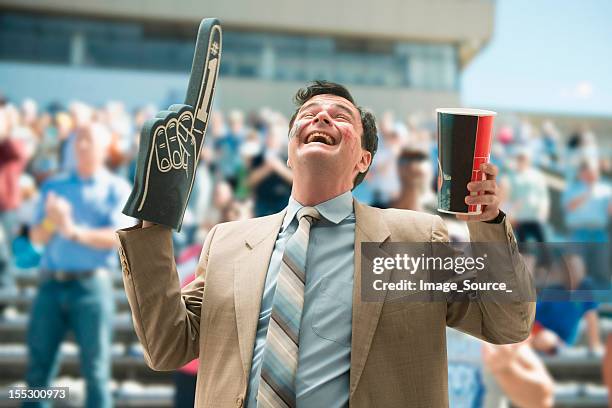 happy businessman sports fan with foam hand and drink - foam hand bildbanksfoton och bilder