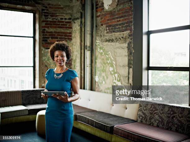 businesswoman in office with digital tablet - minority groups professional stock pictures, royalty-free photos & images