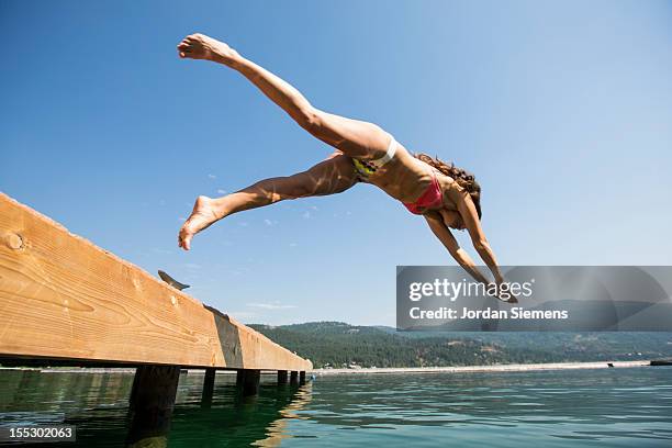 a female dives into the cool water of a lake. - kalispell montana stock-fotos und bilder