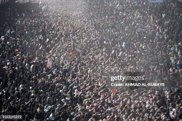 Shiite Muslims take part in a religious ceremony during the climax of the ten-day mourning period of the death of Imam Hussein in the holy city...