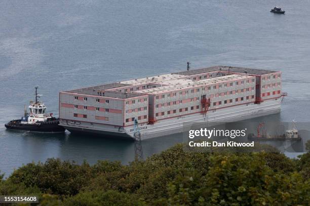 The Bibby Stockholm migrant barge is manoeuvred after arriving at Portland Harbour on July 18, 2023 in Portland, England. The Bibby Stockholm arrives...