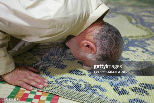 Shiite Muslim worshipper touches his forehead onto a clay tablet during prayer at the Imam Musa al-Kadim mosque in the Shiite Muslim neighborhood of...