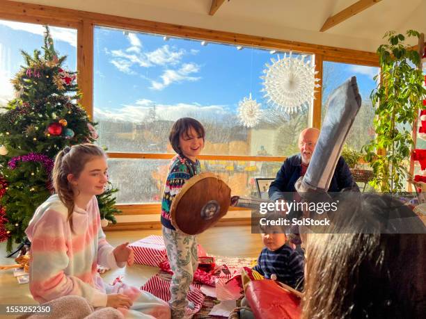 the full family playing with new gifts on christmas - toy sword stock pictures, royalty-free photos & images