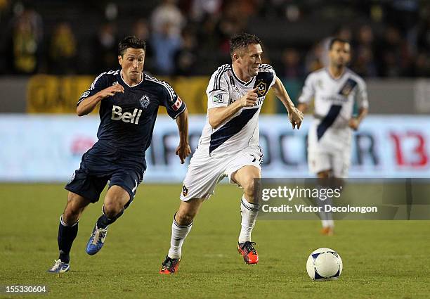 Robbie Keane of the Los Angeles Galaxy paces the ball on the attack as John Thorrington of the Vancouver Whitecaps gives pursuit in the second half...