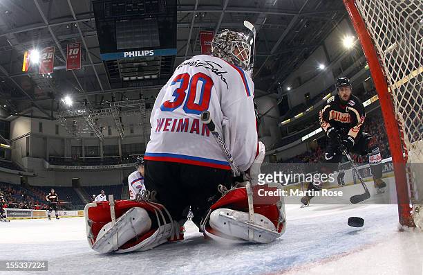 Ivan Ciernik of Hannover scores his team's 3rd goal over Tyler Weiman , goaltender of Nuernberg during the DEL match between Hannover Scorpions and...