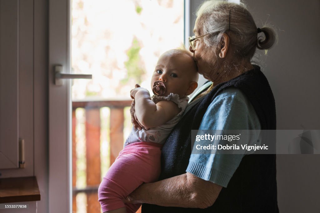 Baby being kissed on the head by grandmother