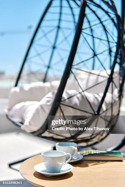 vertical close up shot empty lounge swinging egg chair with cozy white cushion on terraced area - ball chair stock pictures, royalty-free photos & images