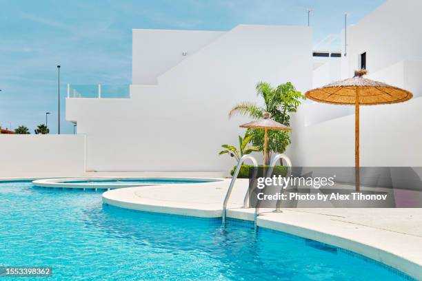empty poolside view at sunny summer day - parasol accesorio personal fotografías e imágenes de stock