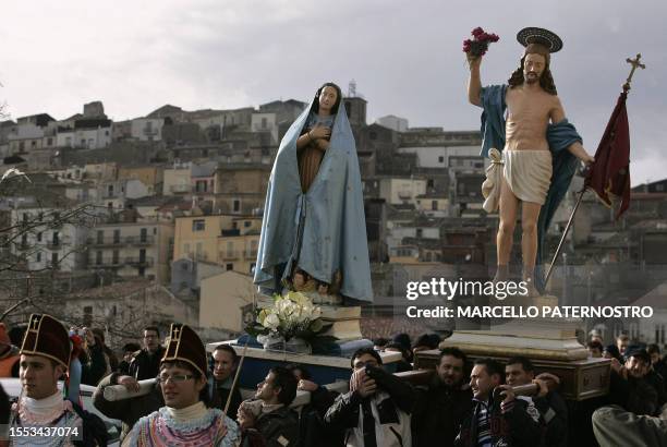 Statues of Christ and Holy Virgin are carried by penitents as they take part in the "Ballu di li Diavuli" during the Easter procession of the small...