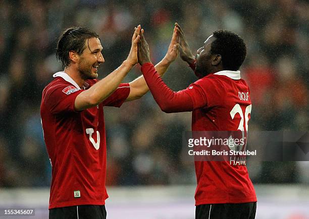 Mame Biram Diouf of Hannover celebrates after scoring his team's first goal with his team mate Christian Schulz during the Bundesliga match between...