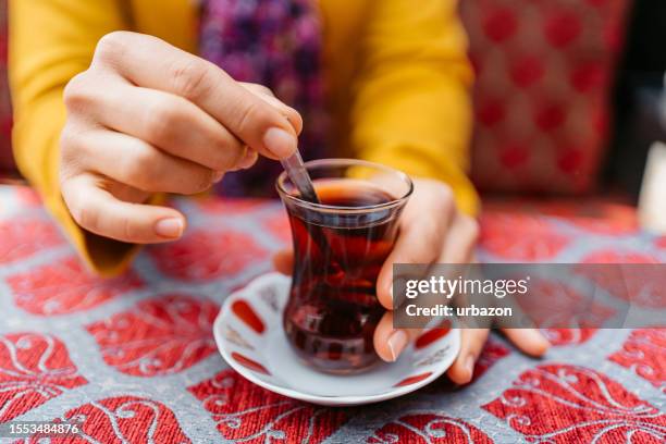 woman drinking traditional turkish tea in a café in istanbul - black tea stock pictures, royalty-free photos & images