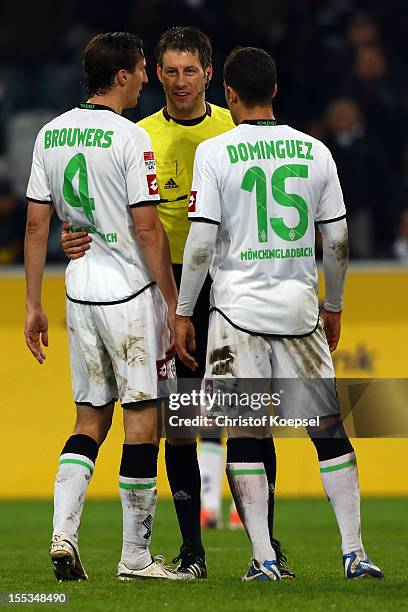 Rouel Brouwers and Alvaro Dominguez of Moenchengladbach discuss with referee Wolfgang Stark after the Bundesliga match between VfL Borussia...