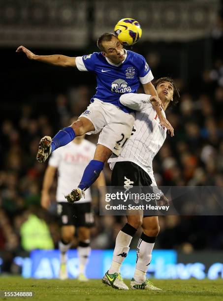 Leon Osman of Everton wins the ball ahead of Bryan Ruiz of Fulham during the Barclays Premier League match between Fulham and Everton at Craven...