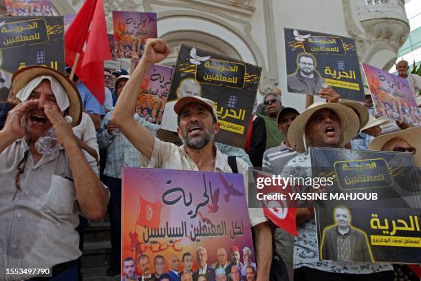 People lift placards demanding the release of political prisoners during an anti-government demonstration organised by the opposition National...
