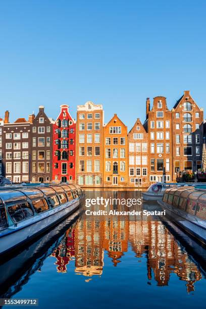 'dancing houses' along damrak canal in amsterdam, holland, netherlands - amsterdam stock pictures, royalty-free photos & images