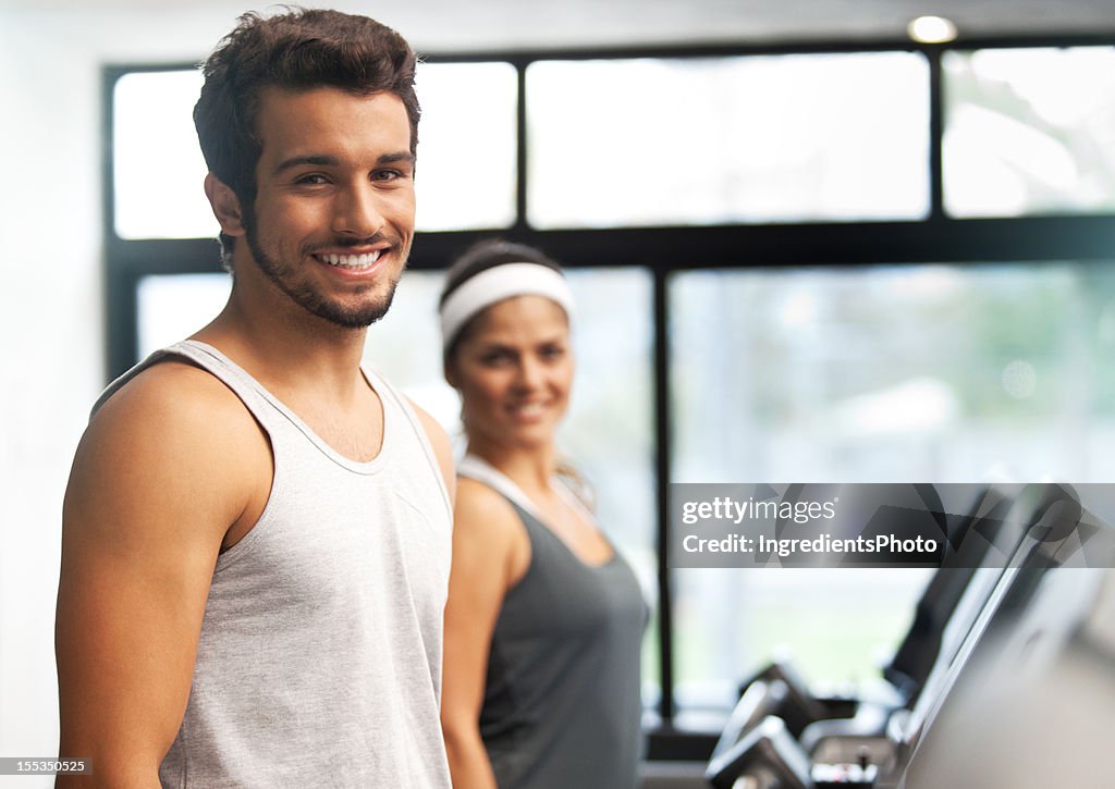 Happy smiling and beautiful people running at the fitness club.