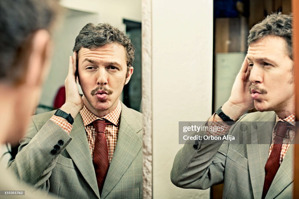 Man looking at reflection in mirror