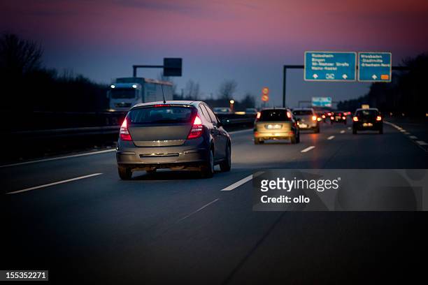 autoroute allemande au crépuscule - phare arrière de véhicule photos et images de collection